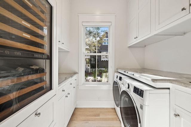 254 E Yacht Pond Ln, Watersound, FL 32461 - washroom with light wood finished floors, baseboards, beverage cooler, cabinet space, and washer and clothes dryer