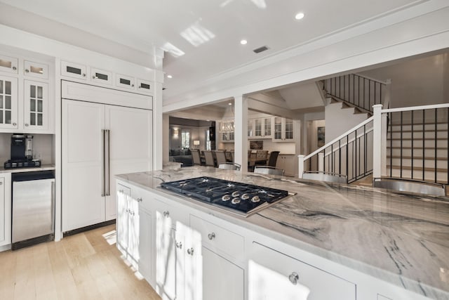 254 E Yacht Pond Ln, Watersound, FL 32461 - kitchen with stainless steel appliances, light wood-style floors, visible vents, white cabinets, and light stone countertops