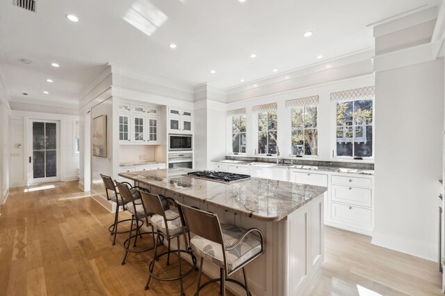 254 E Yacht Pond Ln, Watersound, FL 32461 - kitchen featuring white cabinetry, light stone countertops, stainless steel appliances, and a center island