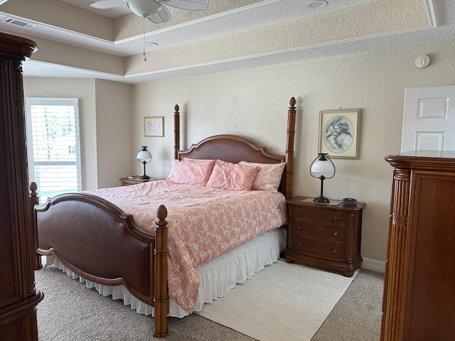 carpeted bedroom with visible vents and a textured wall