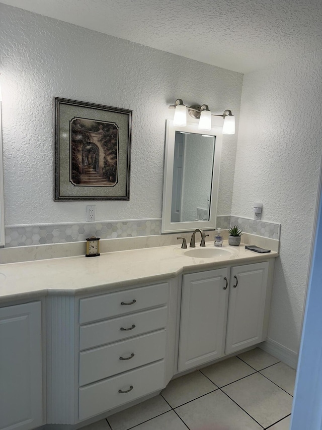 bathroom with vanity, tile patterned floors, and a textured wall