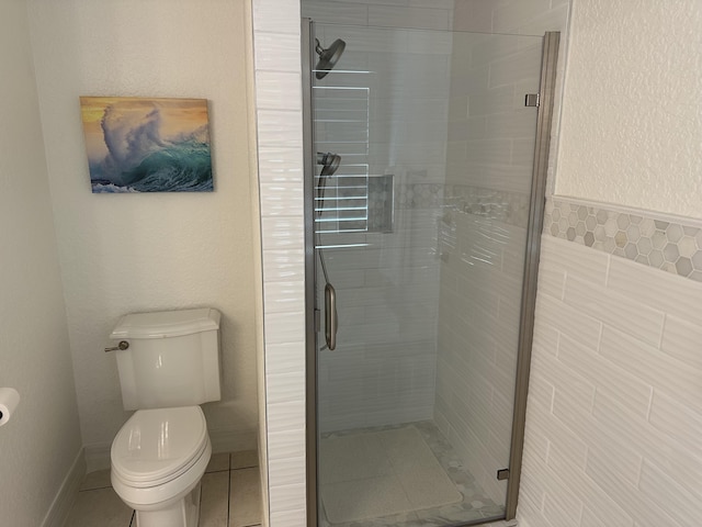 full bath with tile patterned flooring, a shower stall, toilet, and baseboards