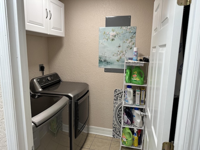 laundry area featuring cabinet space, separate washer and dryer, light tile patterned flooring, and a textured wall