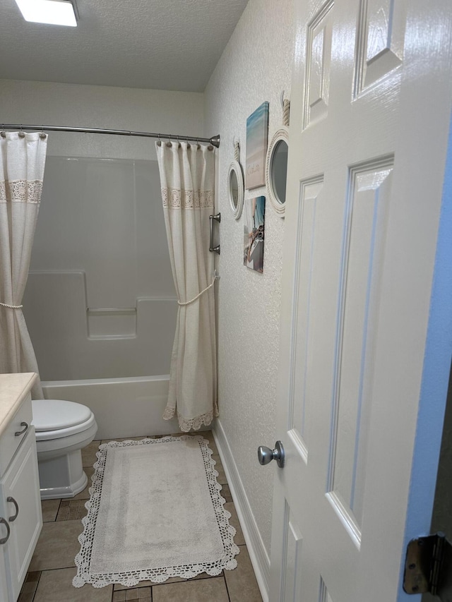 bathroom featuring toilet, a textured ceiling, tile patterned flooring, vanity, and a textured wall