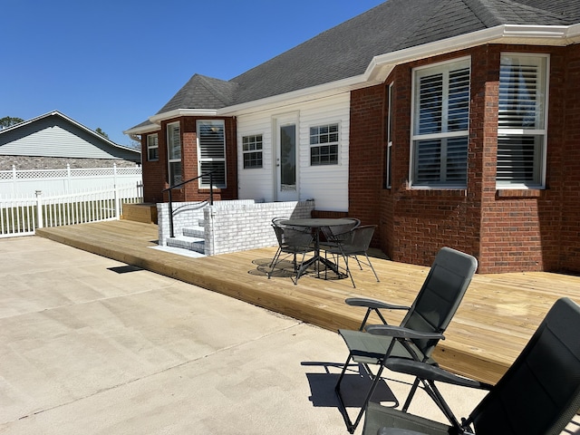 wooden terrace featuring outdoor dining space and fence