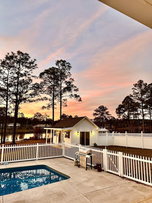 view of pool featuring a fenced in pool, a water view, fence private yard, and a patio area