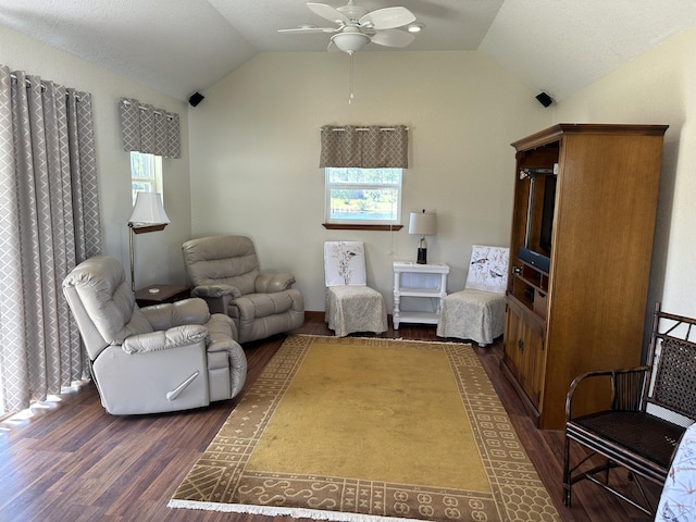 living room with dark wood-style floors, a ceiling fan, and vaulted ceiling