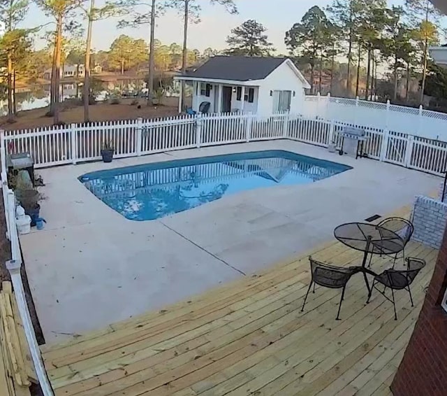 view of swimming pool featuring a fenced in pool, a wooden deck, and fence