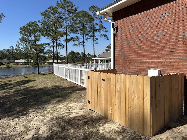 view of yard featuring a water view and fence