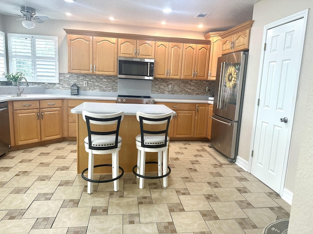 kitchen featuring a sink, visible vents, appliances with stainless steel finishes, and light countertops