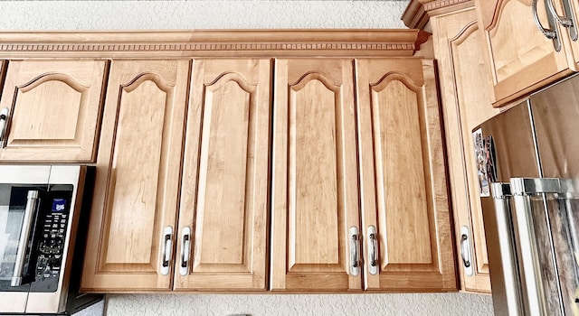 details featuring light brown cabinetry and stainless steel appliances