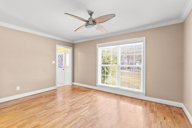 spare room featuring ornamental molding, light wood-type flooring, ceiling fan, and baseboards