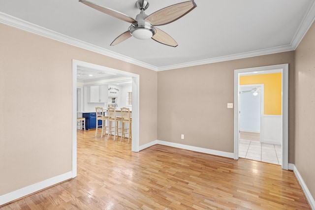 unfurnished room featuring ornamental molding, light wood-type flooring, baseboards, and a ceiling fan