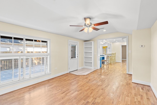 unfurnished room with lofted ceiling, visible vents, light wood-style flooring, and baseboards