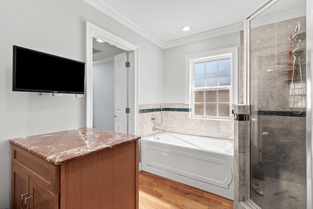 bathroom featuring ornamental molding, wood finished floors, a garden tub, a shower stall, and recessed lighting