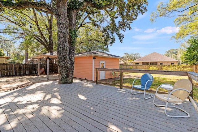 wooden deck featuring a fenced backyard and an outdoor structure