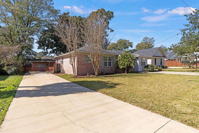 ranch-style home featuring a front yard, driveway, and fence