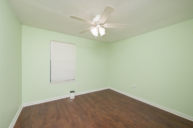 unfurnished room featuring ceiling fan, dark wood-type flooring, and baseboards