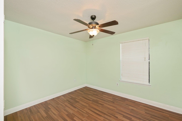 spare room featuring a ceiling fan, dark wood-style flooring, a textured ceiling, and baseboards