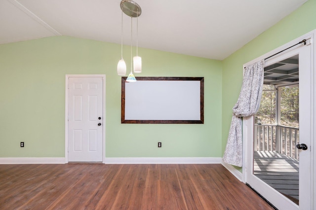 spare room featuring baseboards, vaulted ceiling, and wood finished floors