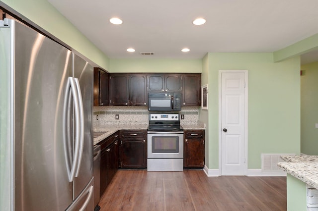 kitchen featuring stainless steel appliances, visible vents, and dark brown cabinetry