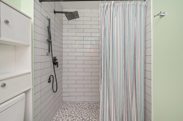 bathroom featuring a shower stall and toilet