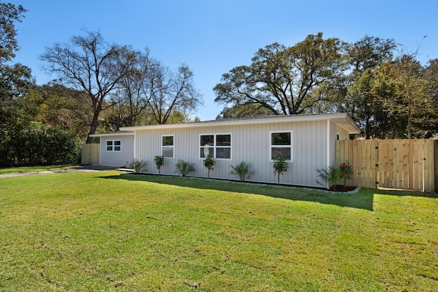 view of front of home featuring fence and a front lawn