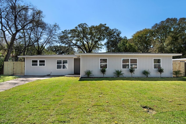 view of front of property featuring driveway, fence, and a front yard