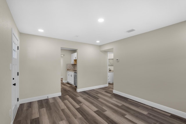 spare room featuring baseboards, visible vents, dark wood-style flooring, and recessed lighting