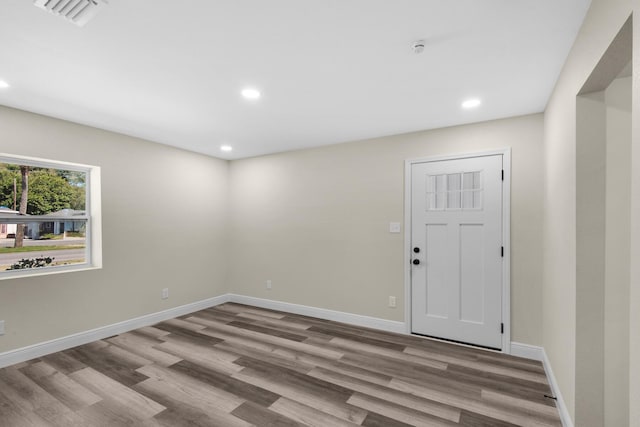 empty room with recessed lighting, wood finished floors, visible vents, and baseboards