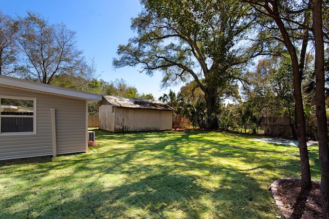 view of yard featuring a storage unit, fence, and an outdoor structure