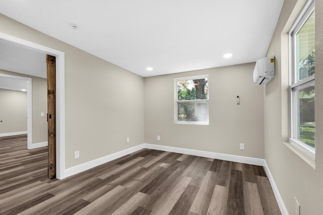 unfurnished room with recessed lighting, dark wood-style flooring, baseboards, and a wall mounted AC