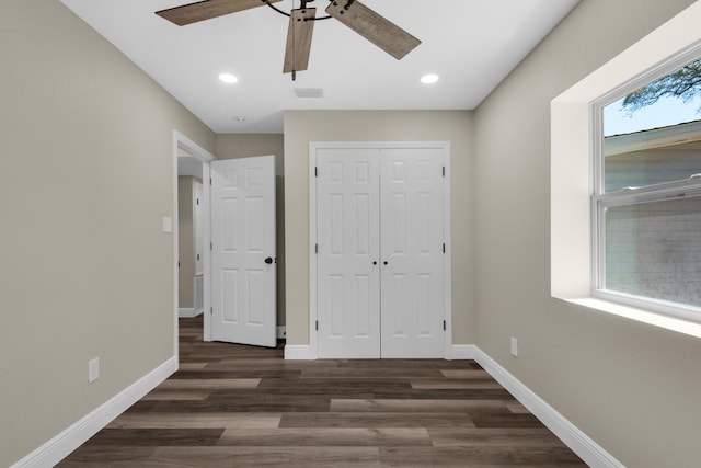 unfurnished bedroom featuring a closet, visible vents, baseboards, and wood finished floors