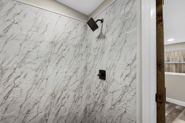 details featuring a tile shower and wood finished floors