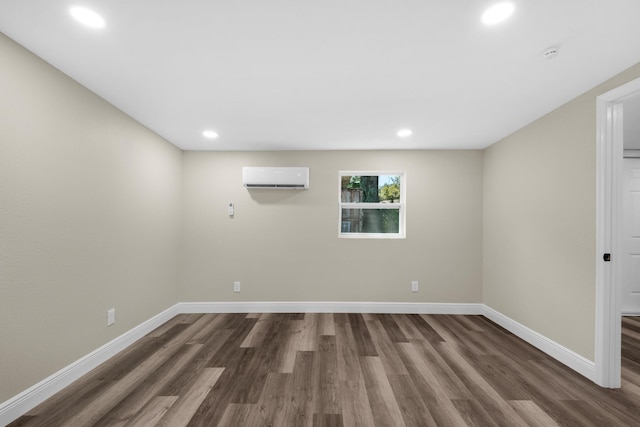 below grade area featuring an AC wall unit, dark wood-style flooring, recessed lighting, and baseboards