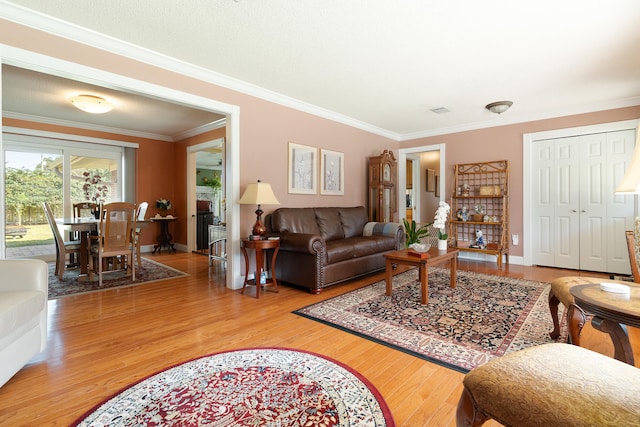 living area with crown molding, baseboards, and wood finished floors