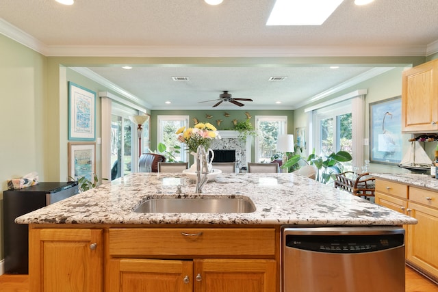 kitchen with light stone counters, visible vents, a high end fireplace, a sink, and stainless steel dishwasher