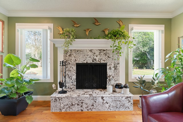 living area featuring a healthy amount of sunlight, crown molding, and wood finished floors