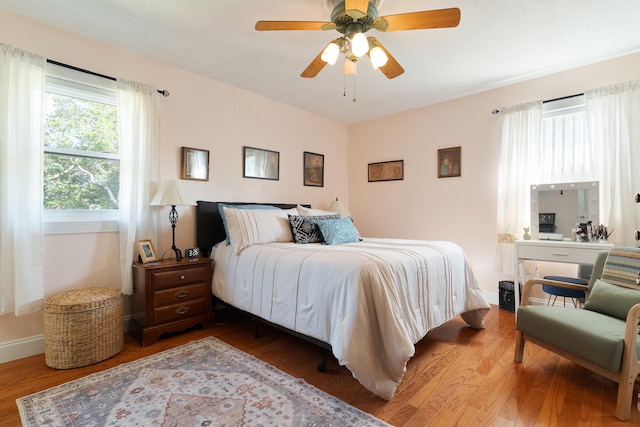 bedroom with ceiling fan, baseboards, and wood finished floors