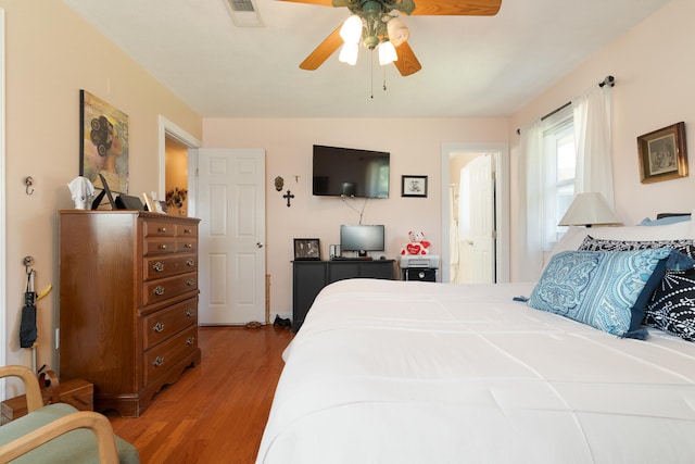 bedroom featuring light wood-type flooring, visible vents, connected bathroom, and a ceiling fan