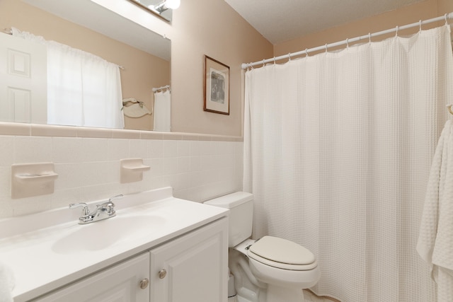 full bathroom with toilet, tile walls, and vanity