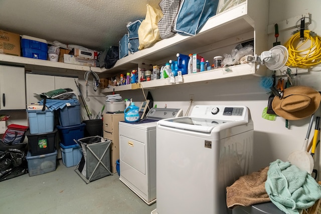 clothes washing area featuring washing machine and clothes dryer, laundry area, and a textured ceiling