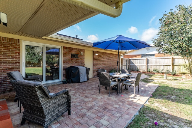 view of patio featuring outdoor dining area, fence, and grilling area