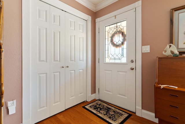 entrance foyer featuring baseboards, light wood-style floors, and ornamental molding