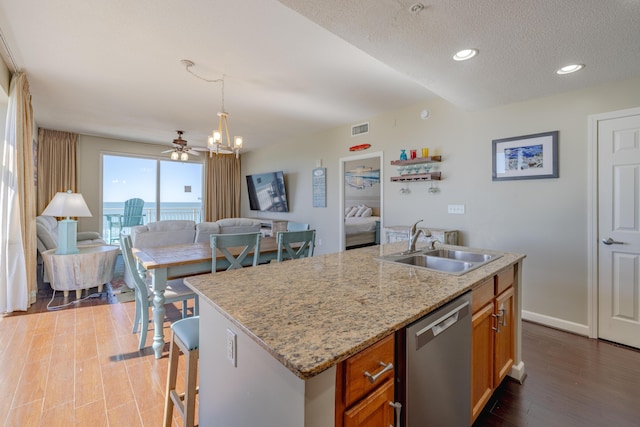 kitchen with a sink, visible vents, open floor plan, and dishwasher