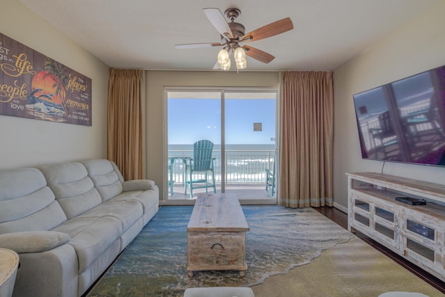 living room featuring ceiling fan, wood finished floors, and baseboards