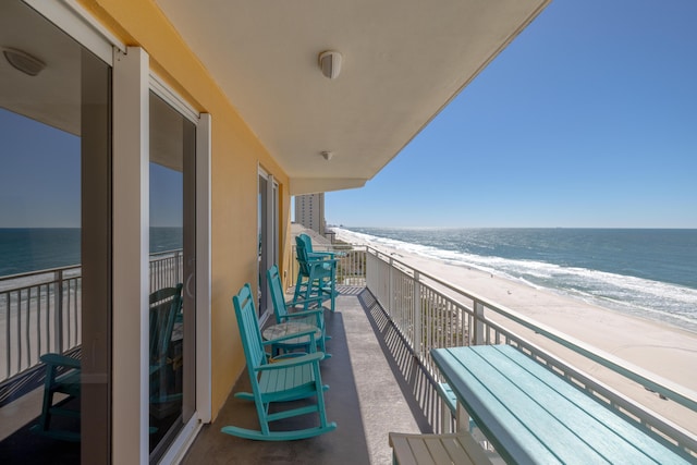 balcony featuring a beach view and a water view