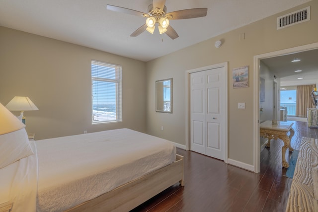 bedroom featuring a closet, visible vents, ceiling fan, wood finished floors, and baseboards