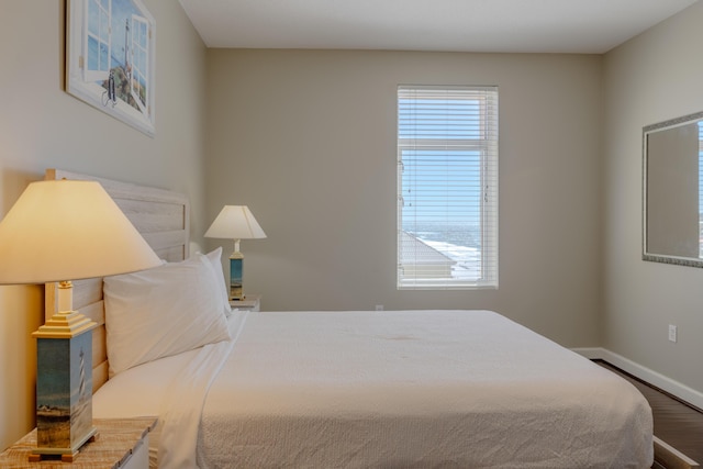 bedroom with baseboards and wood finished floors