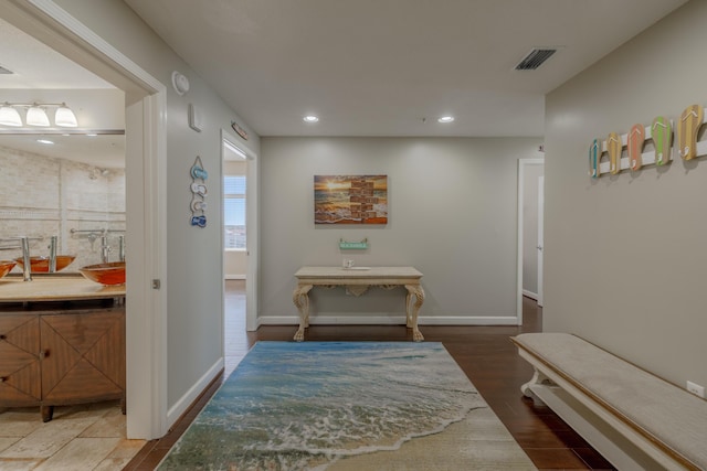 hallway with baseboards, visible vents, wood finished floors, and recessed lighting